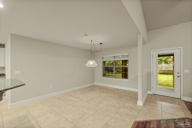 unfurnished dining area featuring light tile patterned flooring and baseboards