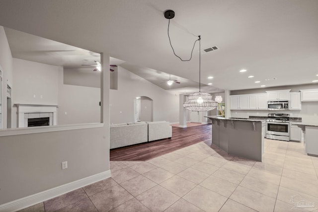 kitchen featuring appliances with stainless steel finishes, a ceiling fan, open floor plan, light tile patterned floors, and recessed lighting