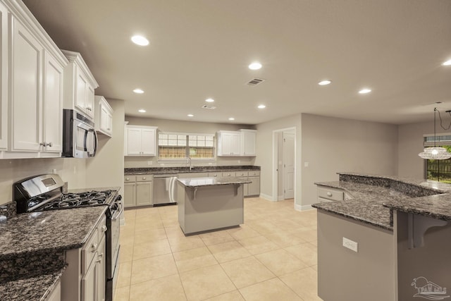 kitchen featuring appliances with stainless steel finishes, a kitchen breakfast bar, a center island, recessed lighting, and a sink