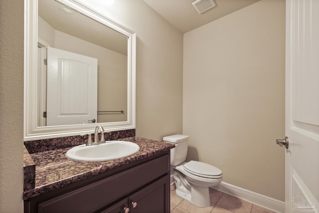 half bath featuring tile patterned flooring, toilet, and vanity