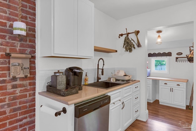 407 Rue Max St, Pensacola, FL 32507 - kitchen featuring stainless steel dishwasher, a sink, decorative backsplash, wood finished floors, and white cabinets