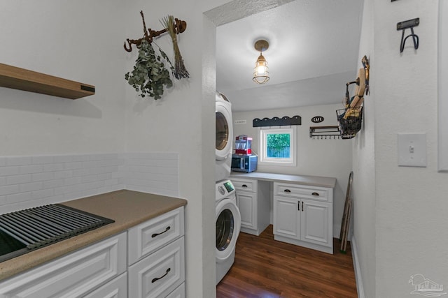 407 Rue Max St, Pensacola, FL 32507 - washroom featuring stacked washer and clothes dryer, dark wood-style flooring, and cabinet space
