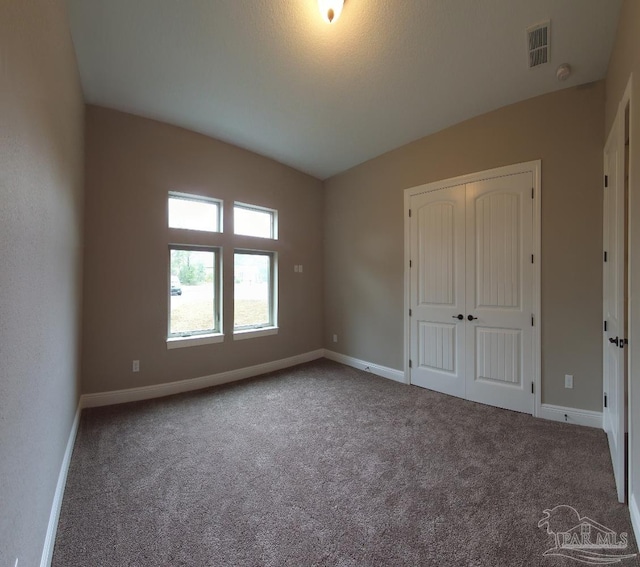 unfurnished bedroom with a closet and carpet flooring