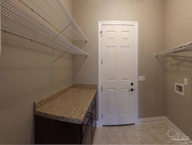clothes washing area featuring washer hookup, baseboards, laundry area, and light tile patterned flooring