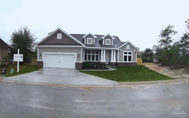 craftsman inspired home featuring a front yard, stone siding, a garage, and concrete driveway