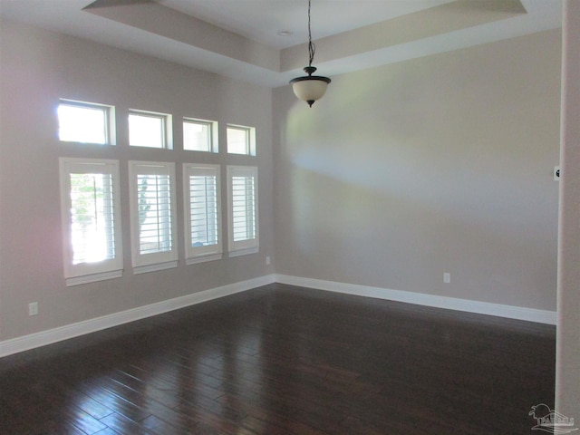 spare room featuring dark wood finished floors and baseboards