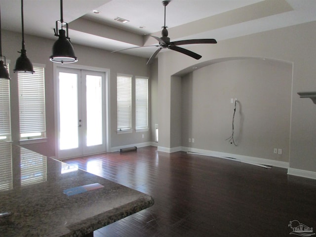 unfurnished living room featuring dark wood-style flooring, visible vents, baseboards, a ceiling fan, and french doors