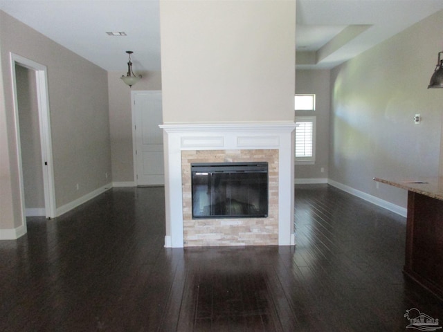 unfurnished living room with baseboards, a fireplace, visible vents, and dark wood finished floors