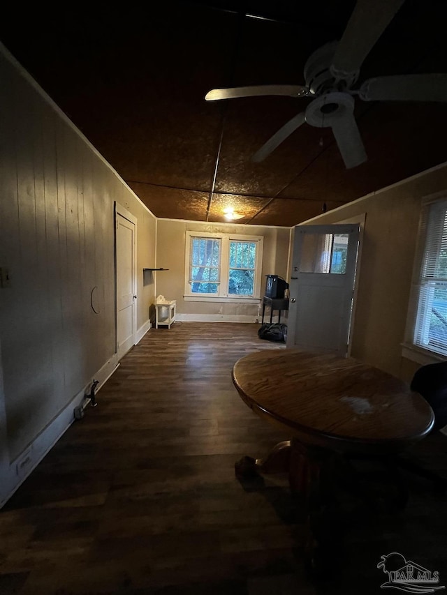 interior space featuring wood-type flooring, ceiling fan, and wood walls