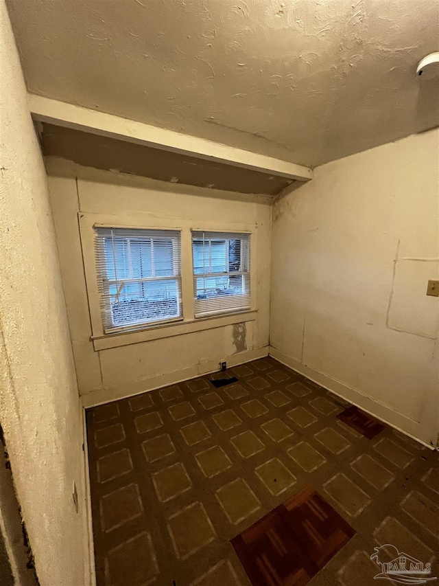 unfurnished room with a textured ceiling