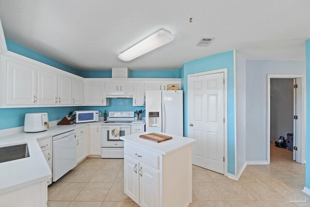 544 Batten Blvd, Pensacola, FL 32507 - kitchen with white appliances, light countertops, light tile patterned flooring, under cabinet range hood, and visible vents