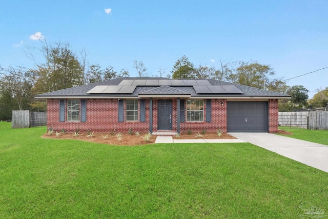 ranch-style house with solar panels, a front yard, and a garage