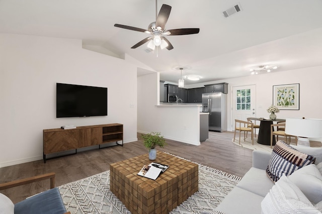 living room featuring ceiling fan, dark wood-type flooring, and lofted ceiling