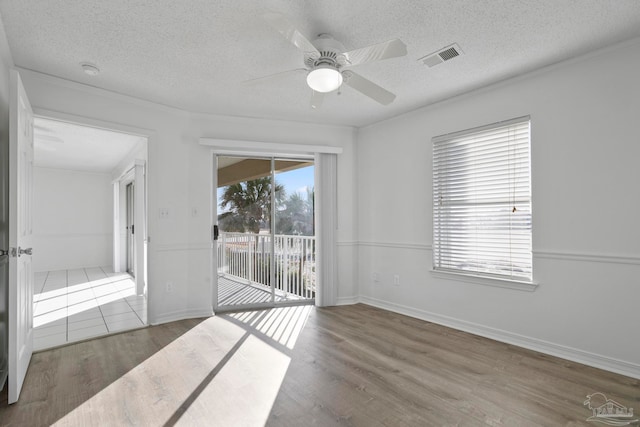 empty room featuring wood-type flooring, ceiling fan, and a textured ceiling