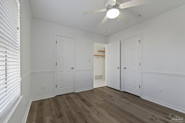 unfurnished bedroom featuring crown molding, dark hardwood / wood-style floors, and ceiling fan