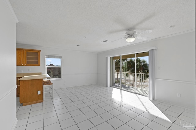 unfurnished living room featuring light tile patterned flooring, a healthy amount of sunlight, and ornamental molding