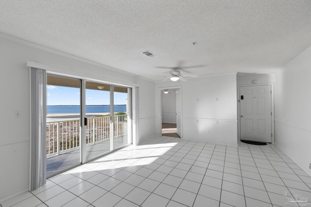 tiled empty room with a water view, a textured ceiling, and ceiling fan