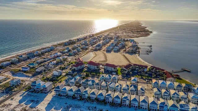 aerial view at dusk with a water view and a beach view