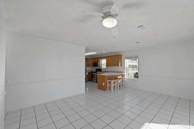 interior space featuring ceiling fan, light tile patterned floors, and sink