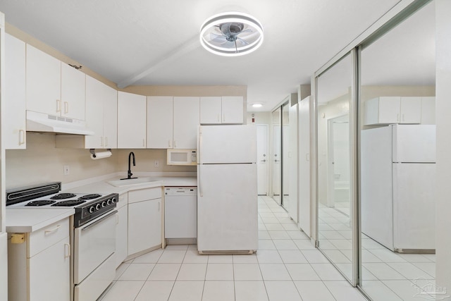 kitchen with light tile patterned flooring, white cabinetry, white appliances, and sink