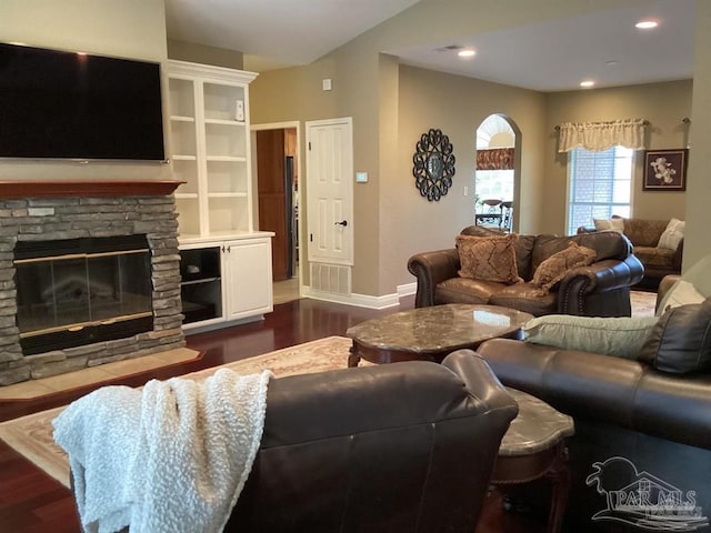 living room featuring dark wood-style floors, a fireplace, baseboards, and recessed lighting