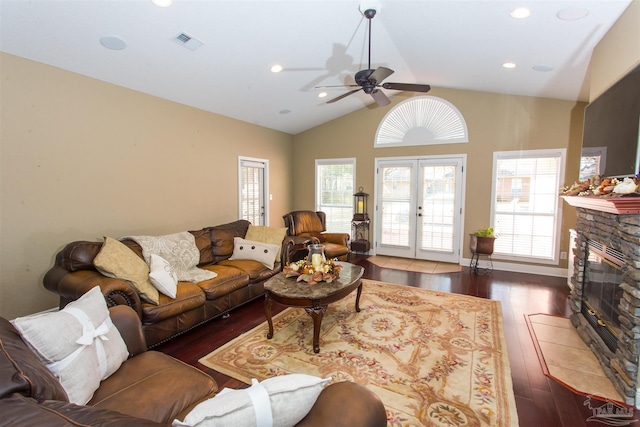 living area with dark wood-style flooring, french doors, a fireplace, visible vents, and vaulted ceiling