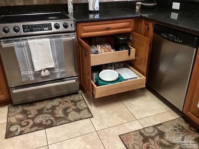 details featuring stainless steel appliances, brown cabinetry, and dark stone countertops