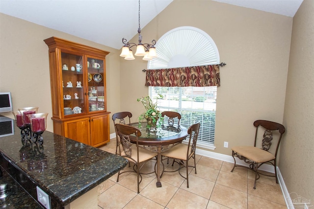 dining space featuring light tile patterned floors, vaulted ceiling, baseboards, and a notable chandelier