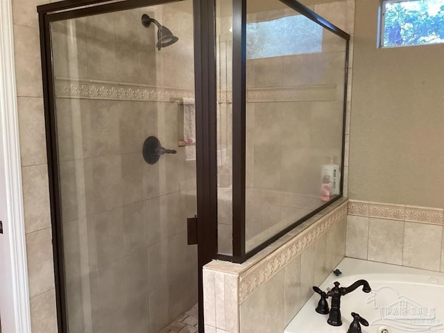 bathroom featuring a stall shower and a bath