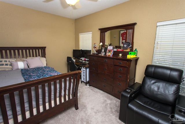 bedroom with light carpet and a ceiling fan