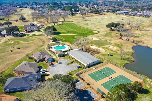 birds eye view of property with golf course view and a water view