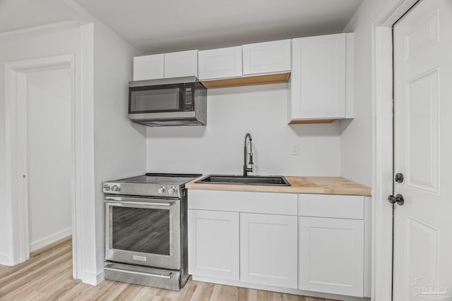 kitchen featuring appliances with stainless steel finishes, sink, and white cabinets