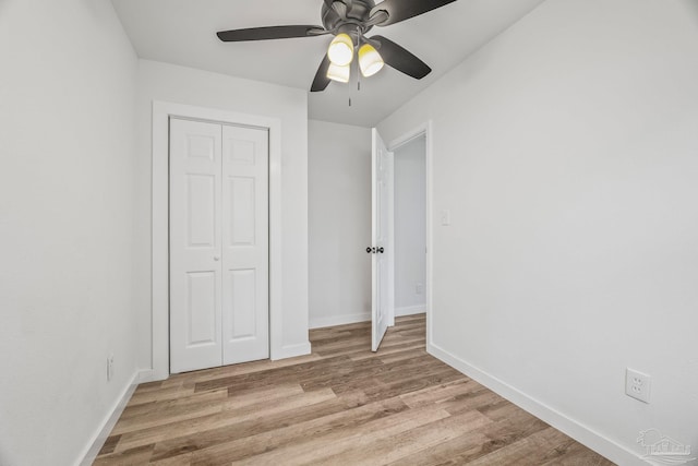 unfurnished bedroom with ceiling fan, a closet, and light wood-type flooring