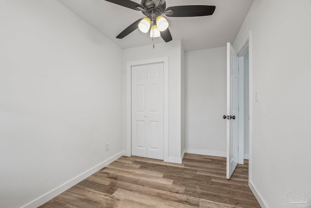 unfurnished bedroom with hardwood / wood-style flooring, a closet, and ceiling fan