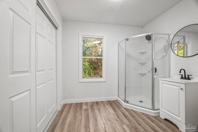 bathroom featuring a shower with door, wood-type flooring, vanity, and crown molding