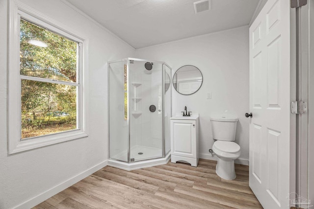 bathroom with sink, crown molding, hardwood / wood-style flooring, toilet, and walk in shower