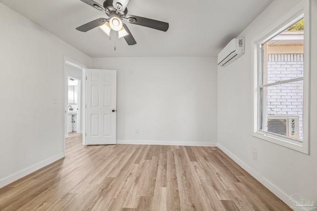 unfurnished room featuring ceiling fan, a wall mounted air conditioner, and light wood-type flooring