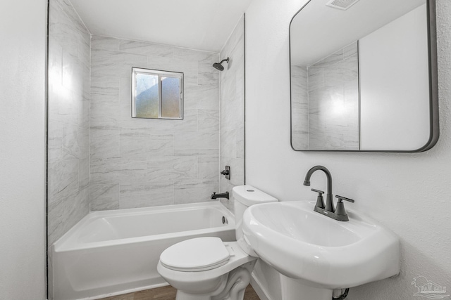 full bathroom with tiled shower / bath, toilet, and sink