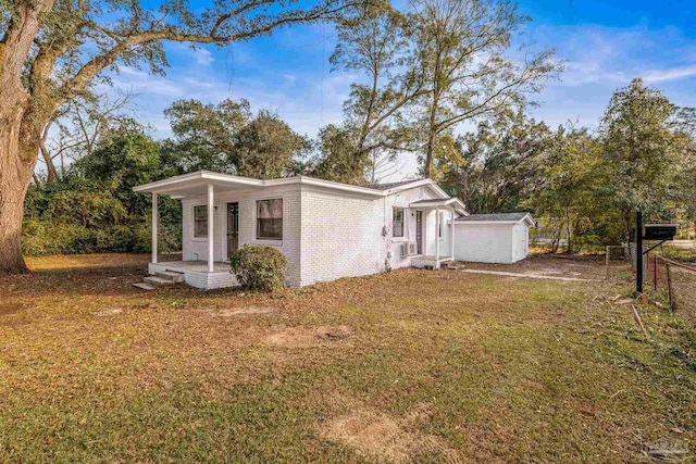 view of side of home with a shed and a lawn