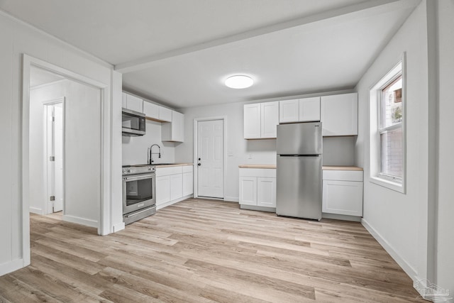 kitchen featuring sink, stainless steel appliances, and white cabinets