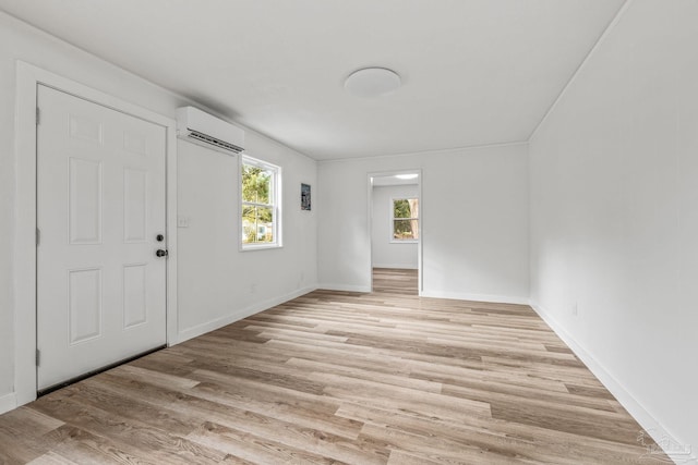 foyer with an AC wall unit and light wood-type flooring