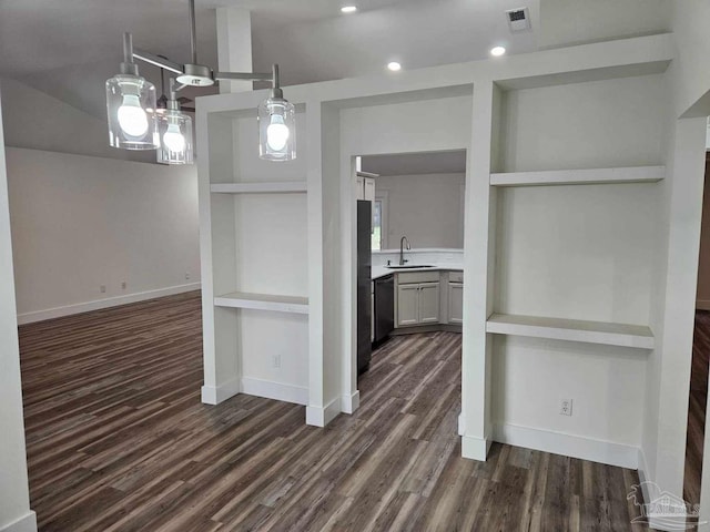 kitchen featuring dishwasher, built in shelves, dark hardwood / wood-style floors, and sink