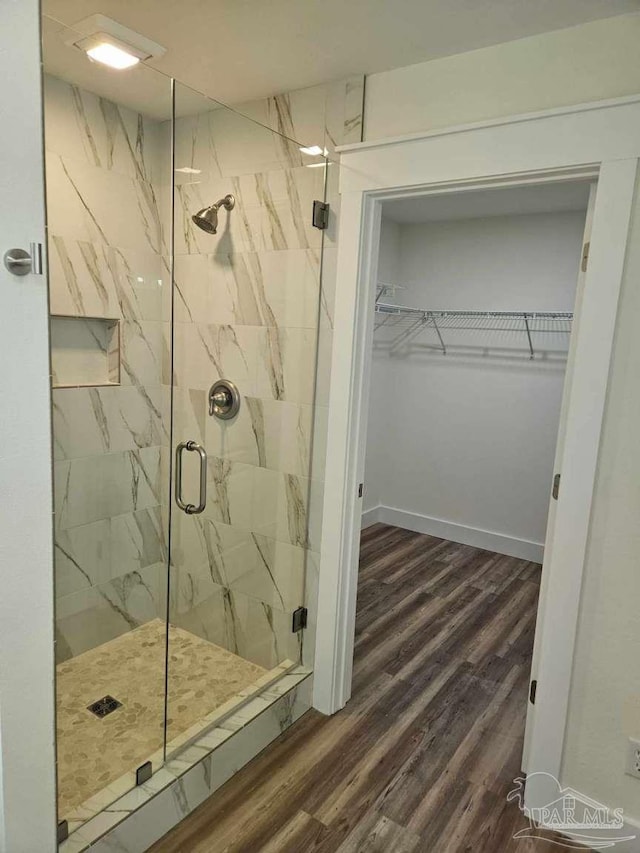 bathroom featuring hardwood / wood-style floors and a shower with door