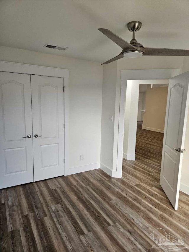 unfurnished bedroom featuring ceiling fan, hardwood / wood-style flooring, and a closet