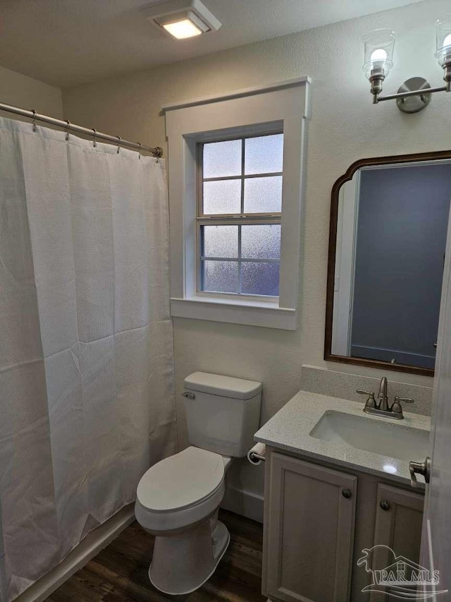 bathroom with toilet, a shower with curtain, hardwood / wood-style floors, and vanity