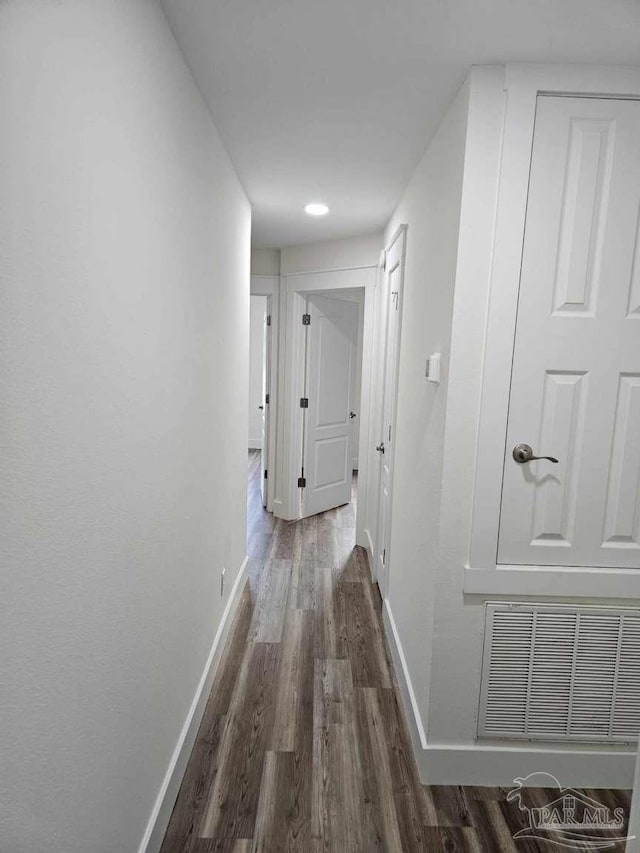 corridor with dark hardwood / wood-style flooring