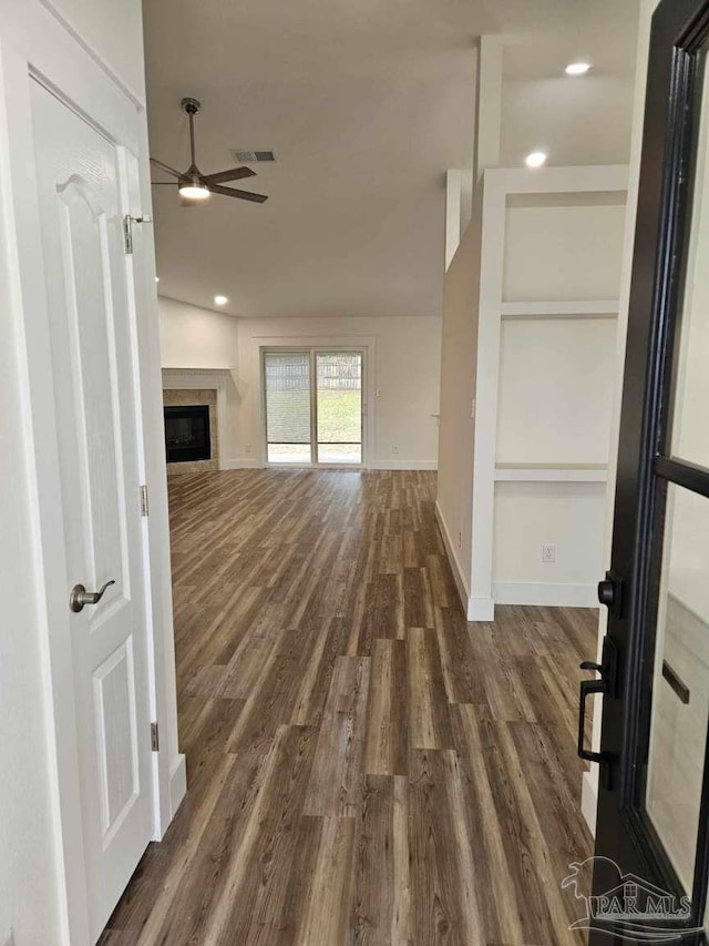 unfurnished living room with ceiling fan and dark wood-type flooring