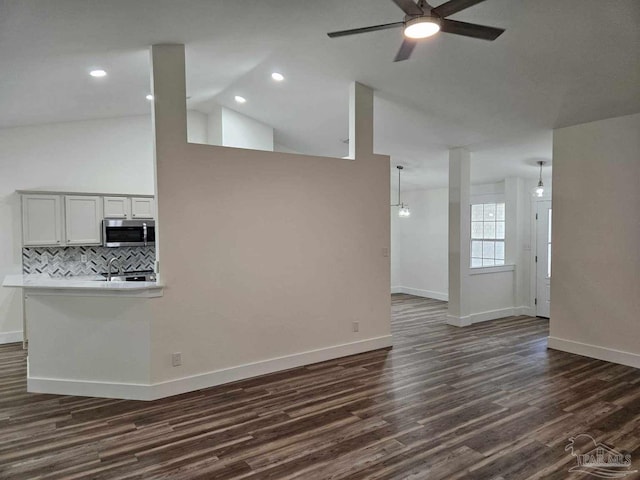 unfurnished living room with ceiling fan, dark hardwood / wood-style floors, and high vaulted ceiling