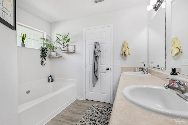 6439 Dallas Ave, Pensacola, FL 32526 - full bath featuring a sink, double vanity, a bath, and wood finished floors