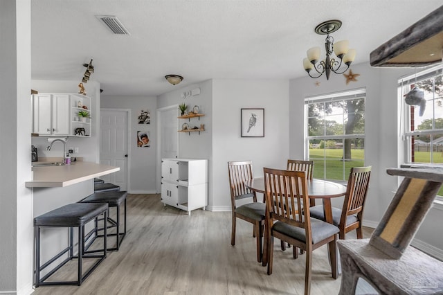 6439 Dallas Ave, Pensacola, FL 32526 - dining room with baseboards, a notable chandelier, light wood finished floors, and visible vents